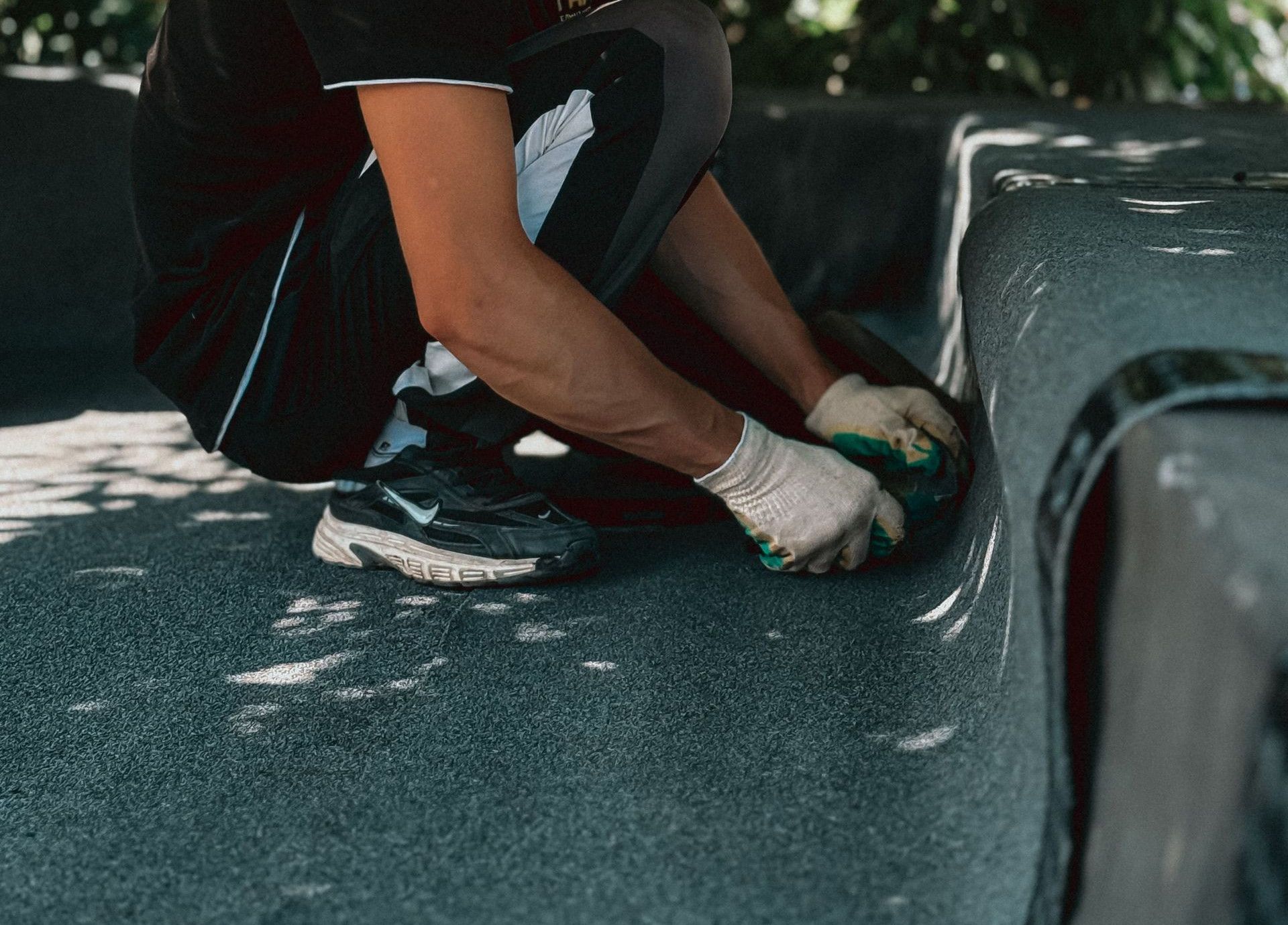 A skilled worker installing roofing material outdoors, showcasing construction expertise and precision.